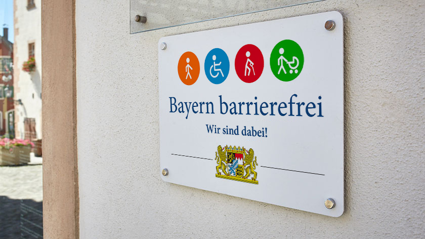 Das Signet „Bayern barrierefrei“ an einer Hauswand.