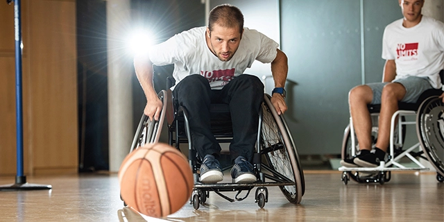 In einer Sporthalle: Zwei Männer beim Rollstuhlbasketball.