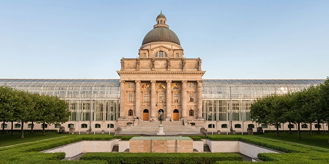 Die Bayerische Staatskanzlei, davor ein Teil des Hofgartens.