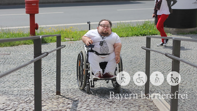 Eine gepflasterte Rampe mündet in einen Gehweg. 