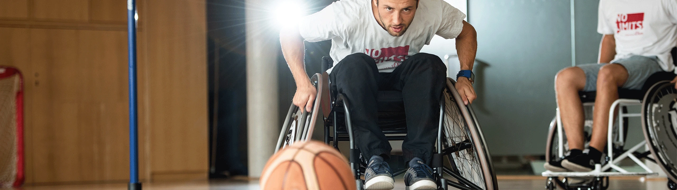 In einer Sporthalle: Zwei Männer beim Rollstuhlbasketball.