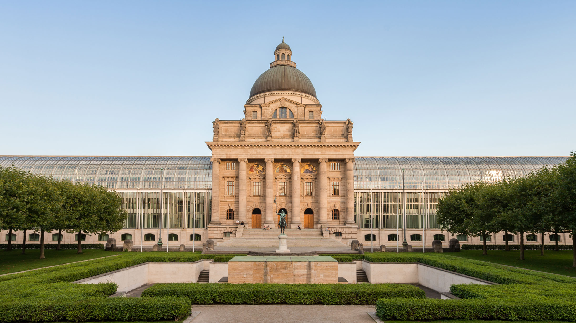 Die Bayerische Staatskanzlei, davor ein Teil des Hofgartens.